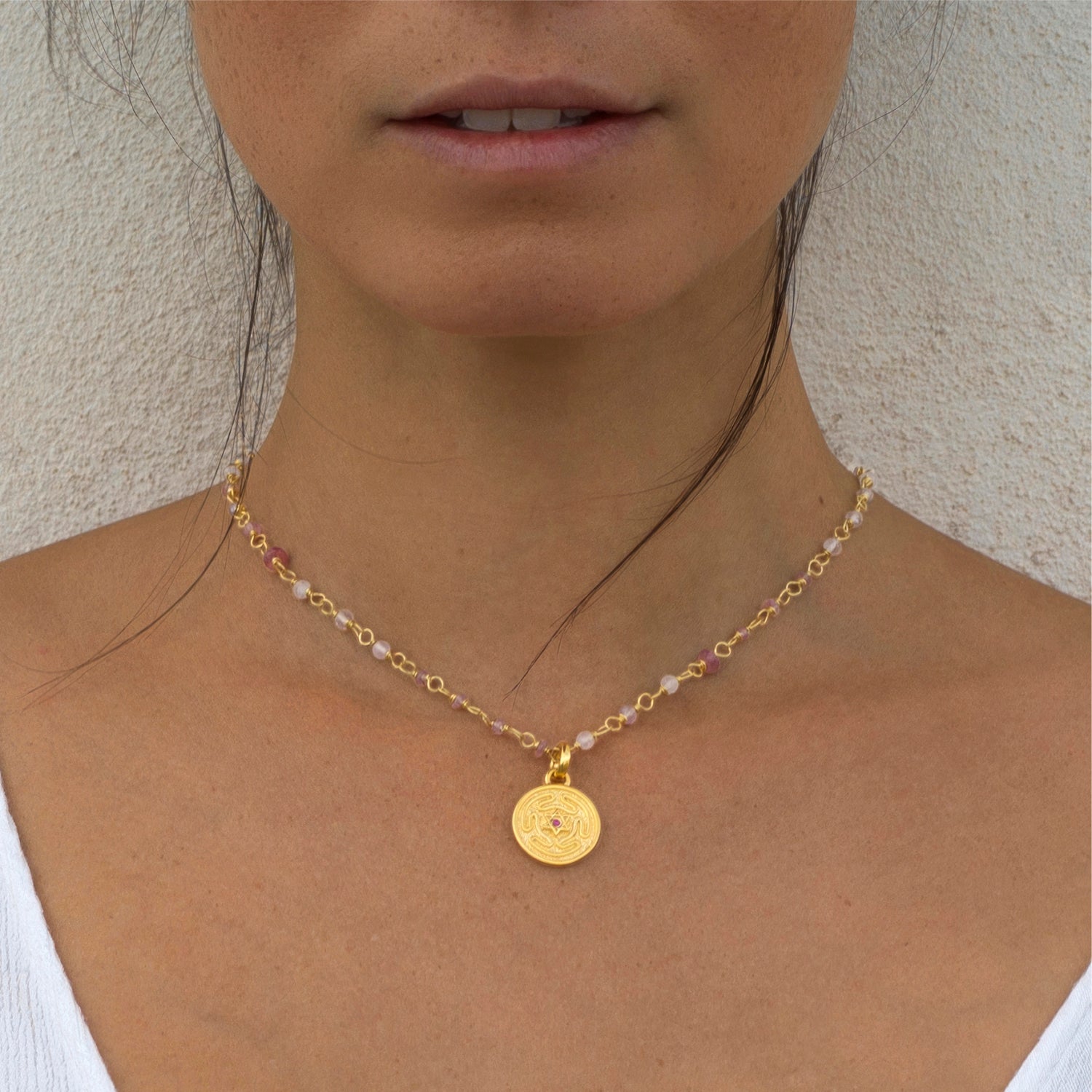 Detail von: Die Yogalehrerin Steffi trägt einen kleinen Hekates-Rad-Anhänger aus vergoldeten Sterling Silber mit Rubin an einer Edelsteinkette von ETERNAL BLISS - Thema Shakti Energie
