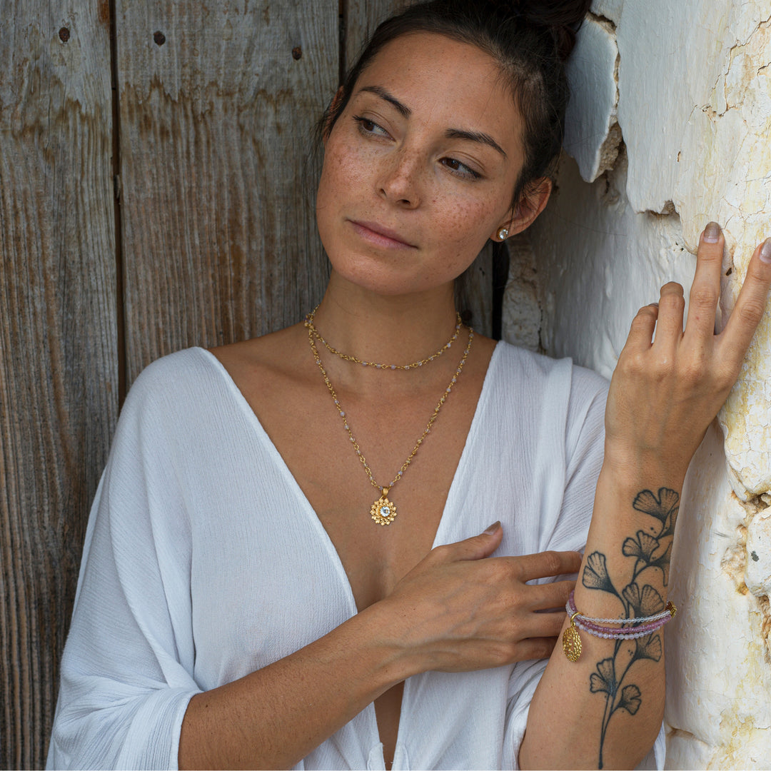 Die Yogalehrerin Steffi trägt eine Kronen Chakra Kette, Chakra Ohrstecker und ein Chakra Edelstein Armband aus der Chakra Schmuck Kollektion