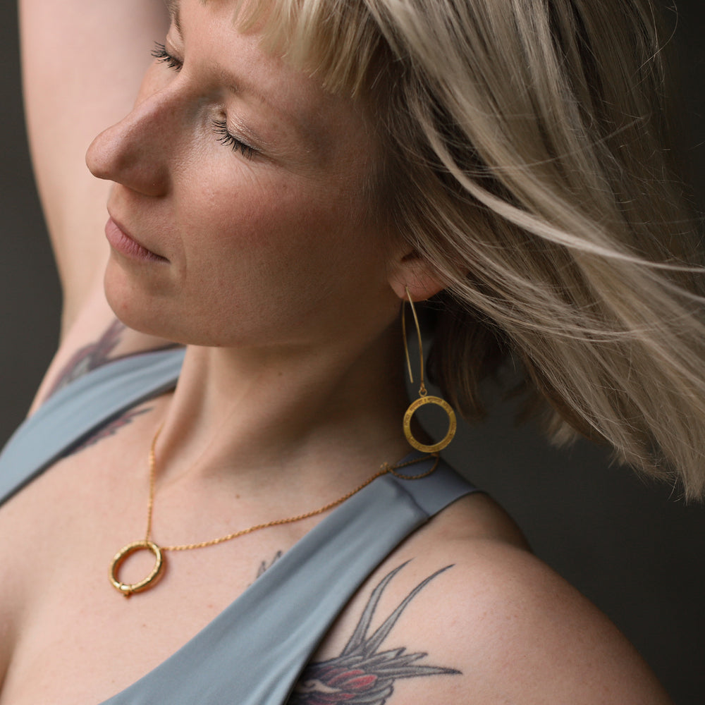 Maria Birnbaum, Yoga Lehrerin in Berliun, trägt einen Shiva Mantra Ohrhänger mit langen Haken aus 24kt vergoldetem Sterling Silber von ETERNAL BLISS zu ihrer hochwertig vergoldeten Shiva Mantra Kette