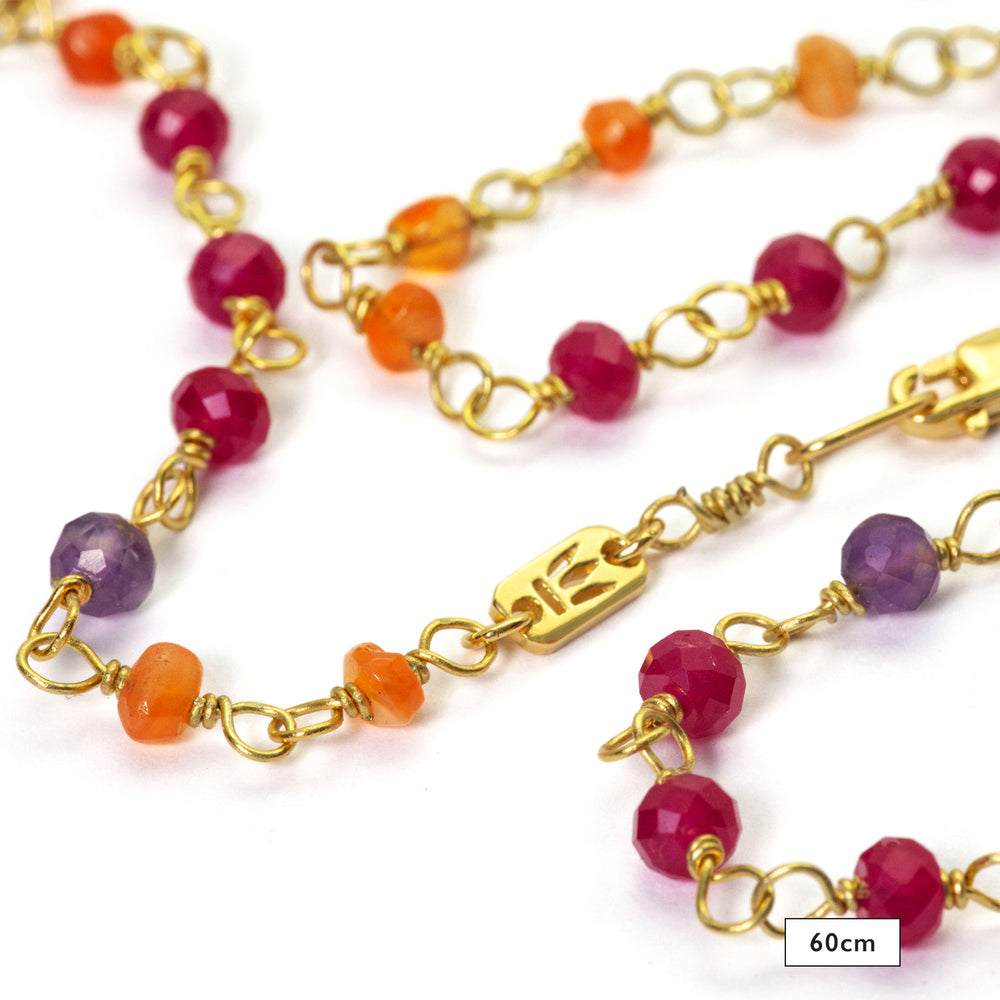 Detail of the powerfully luminous gemstone necklace "Prana" made of high-quality gold-plated sterling silver with rubies, carnelians and amethyst by Eternal Bliss