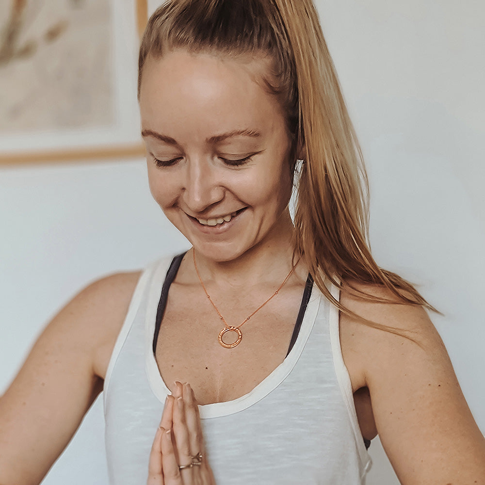 Hedy trägt eine Gayatri Mantra Kette in rosé vergoldetem Sterling Silber aus der Yoga Schmuckkollektion