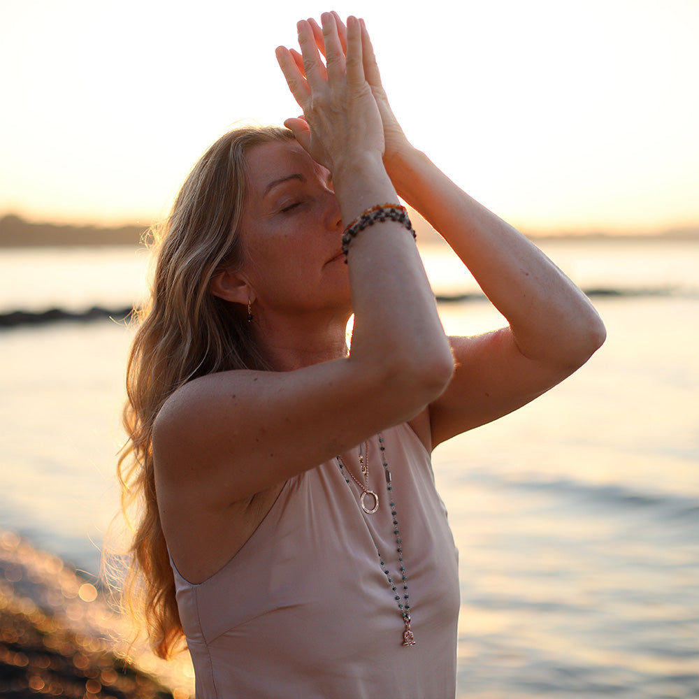 Die Frankfurter Reiki Therapeutin Corinna Marx trägt einen Lehrender-Buddha-Schmuckanhänger aus rosévergoldetem Sterling Silber an einer langen Jadekette