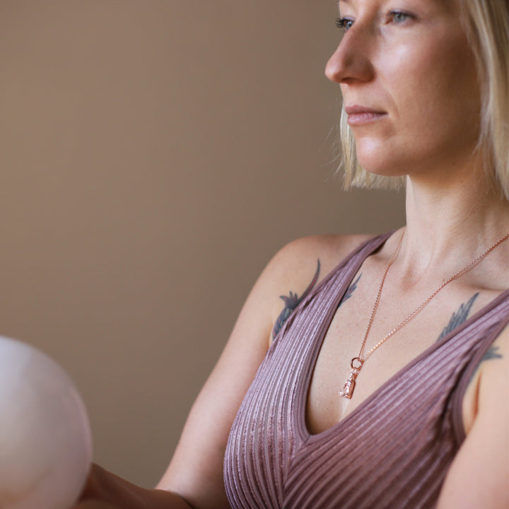 Die Berliner Yoga Lehrerin Maria trägt einen Lehrender-Buddha-Schmuckanhänger aus rosévergoldetem Sterling Silber  vzu ihrer Yoga Session