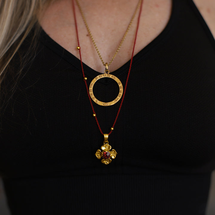 Closeup von Hedys Wurzel Chakra Kette mit einem Granat Edelstein aus hochwertig vergoldetem Sterling Silber von ETERNAL BLISS