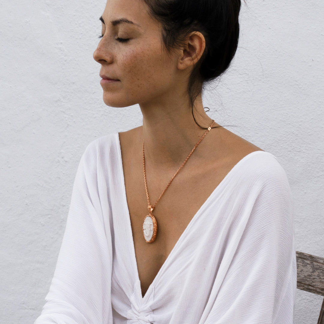 Die Yogalehrerin Steffi bei der Meditation, trägt einen hochwertig rosé vergoldeten Ganesha Anhänger mit geschnitztem Einleger und reich verziertem Rahmen mit Om-Emblem auf der Rückseite von ETERNAL BLISS - Spiritueller Schmuck