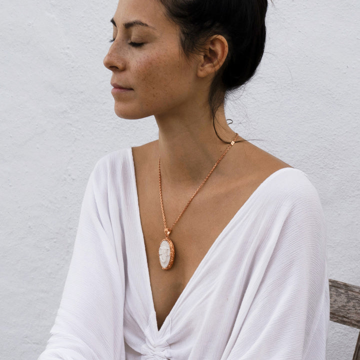 Die Yogalehrerin Steffi bei der Meditation, trägt einen hochwertig rosé vergoldeten Ganesha Anhänger mit geschnitztem Einleger und reich verziertem Rahmen mit Om-Emblem auf der Rückseite von ETERNAL BLISS - Spiritueller Schmuck