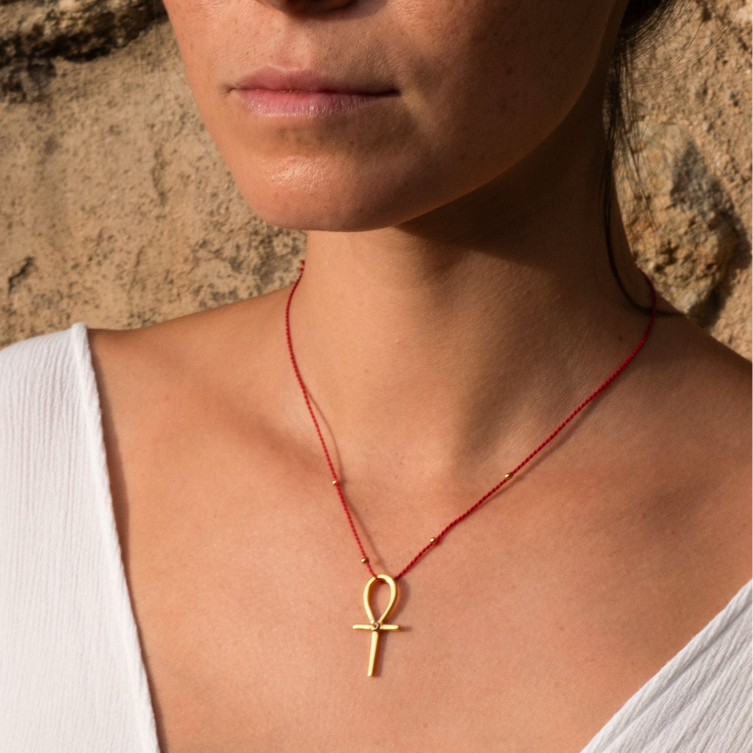 Detailaufnahme von Yoga Teacher Steffi, die einen hochwertig vergoldeten Ankh-Anhänger mit Rubin von ETERNAL BLISS - Schlüssel des Lebens trägt.