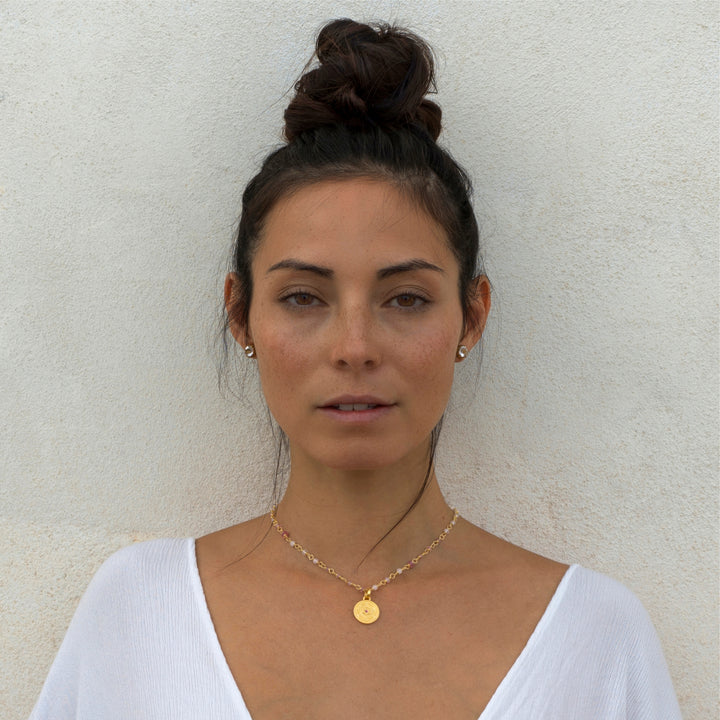 Die Yogalehrerin Steffi trägt einen kleinen Hekates-Rad-Anhänger aus vergoldeten Sterling Silber mit Rubin an einer Edelsteinkette von ETERNAL BLISS - Thema Shakti Energie