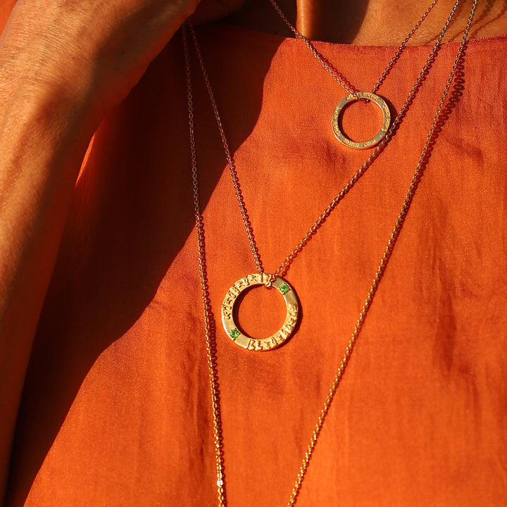 Detailaufnahme von: Cora, die Inhaberin von ETERNALBLISS, trägt zu ihrer Yogapraxis den vergoldeten Tara Mantra Anhänger aus Sterling Silber mit 2 Peridots