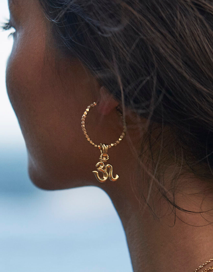 Unser Modell Steffi trägt Mini OM Kreolen mit tibetischen Beads aus Sterling Silber vergoldet