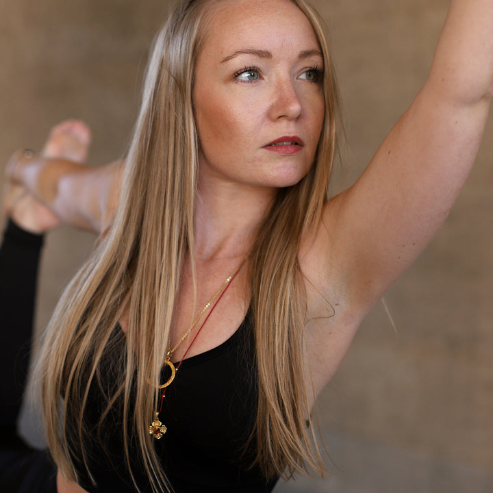 Hedy, Yogalehrerin in Wiesbaden, trägt eine Wurzel Chakra Kette mit einem Granat Edelstein aus hochwertig vergoldetem Sterling Silber von ETERNAL BLISS