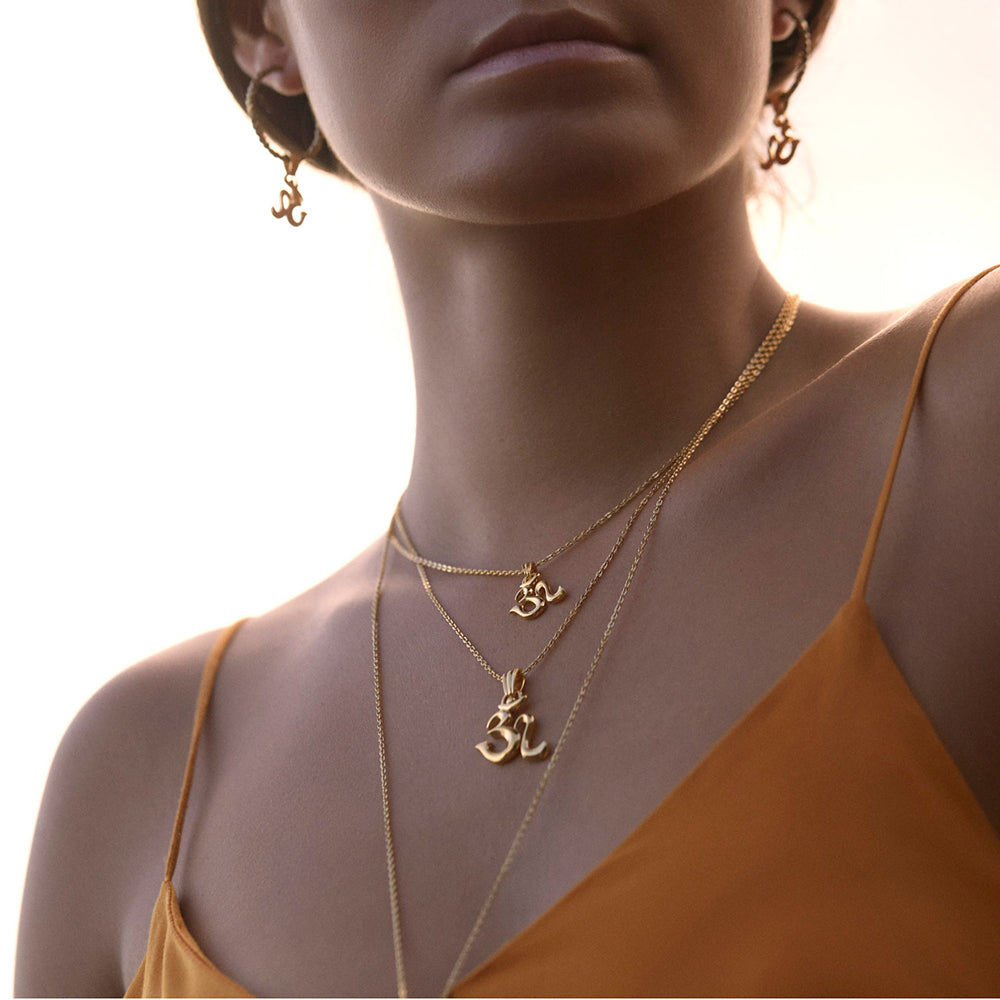 Gold-plated necklaces with Om pendant and Om pendant mini are worn by yoga teacher and model Steffi