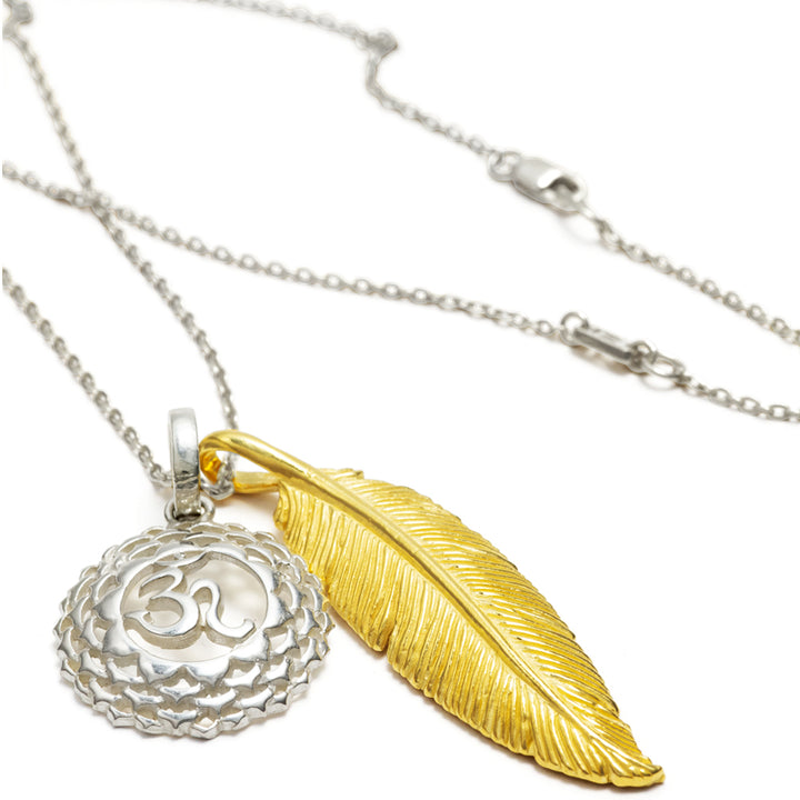 Hochwertige Halskette bicolor "Leichtigkeit &amp; Weite" zusammengestellt aus einem silbernen Kronenchakraanhänger, einem vergoldeten Federanhänger und einer feinen Ankerkette, liegende Ansicht